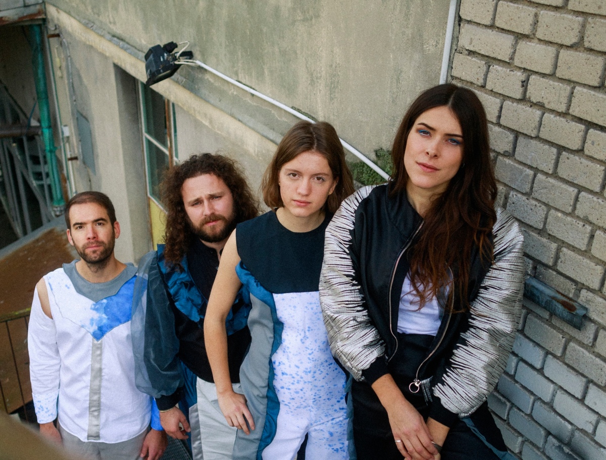 die vier Musiker:innen von BARANY stehen hintereinander auf der Treppe und schauen hoch in die Kamera