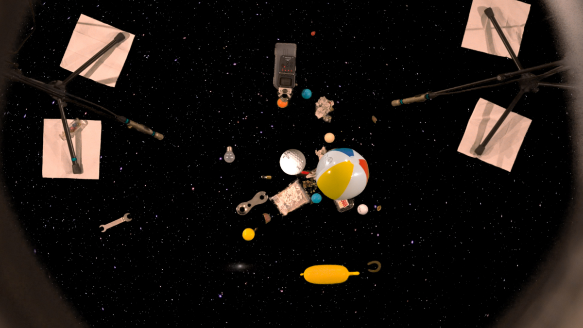 ein Zusammenspiel aus Sternenhimmel, Spielzeug und aufgestellten Mikrofonen bildet ein relativ dunkles Bild mit bunten Farbkleksen ab