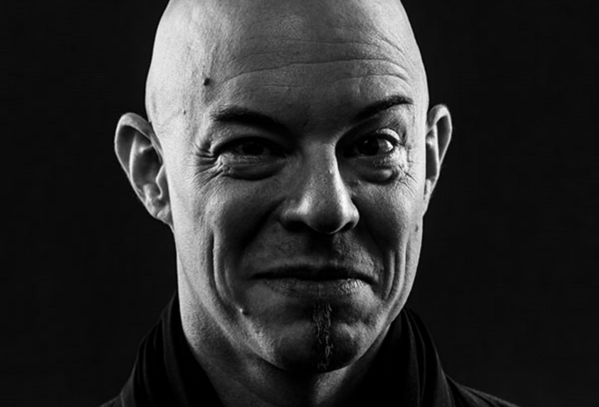 schwarz weiss Portrait von Nik Bärtsch, der verschmitzt in die Kamera schaut