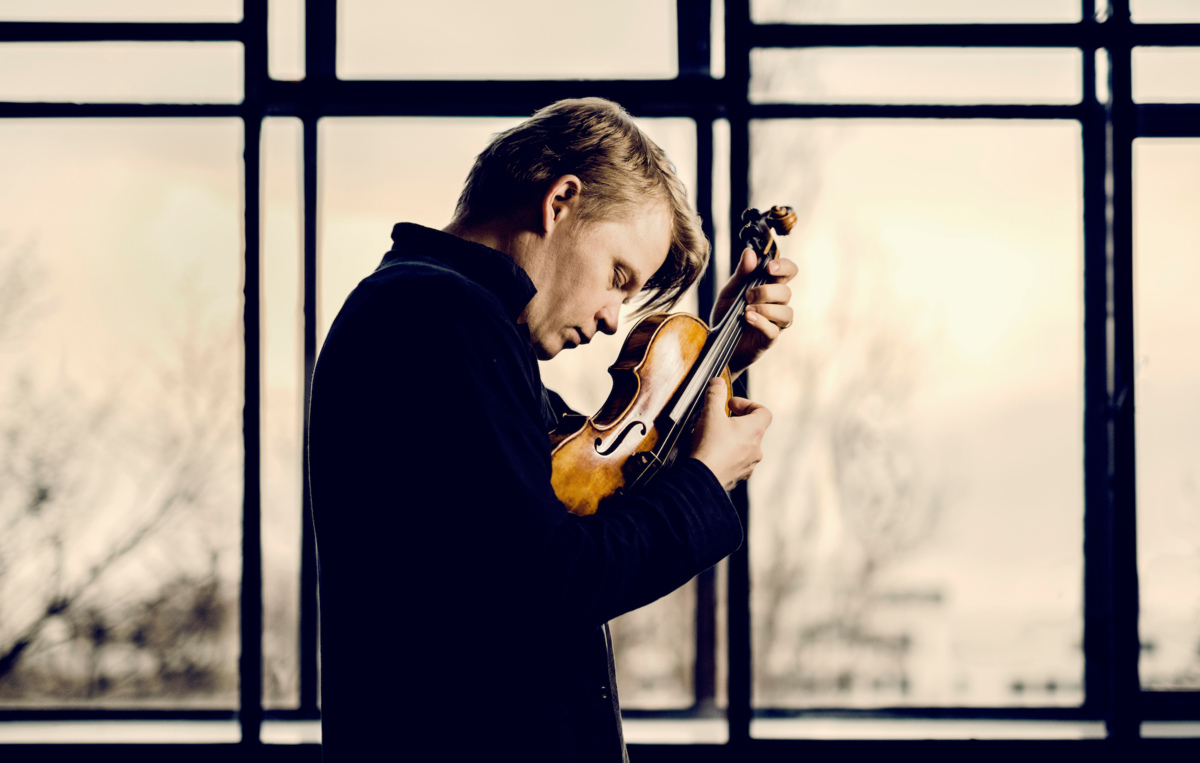 Foto: Das Bild zeigt den Violinisten Pekka Kuuisto mit seiner Geige in den Händen.