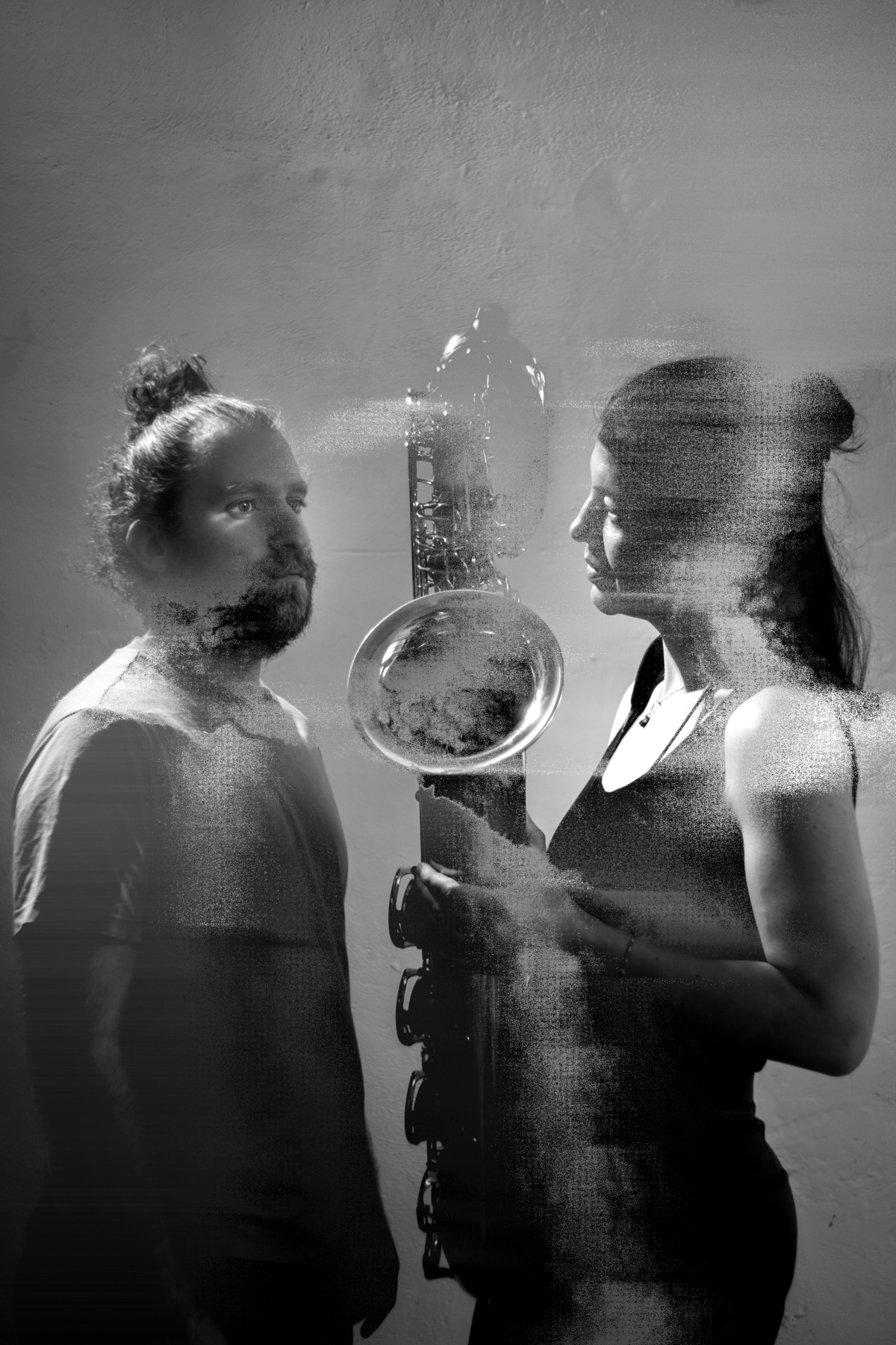 verwischter Mann und verwischte Frau, die ein Saxophon hält in schwarz weiss