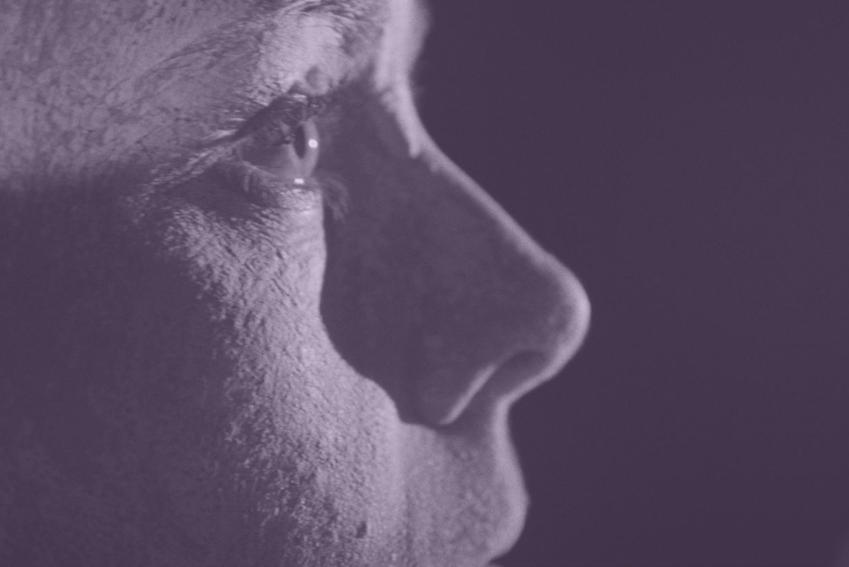 Nahaufnahme eines menschlichen Gesichts im Profil in violettem Licht.