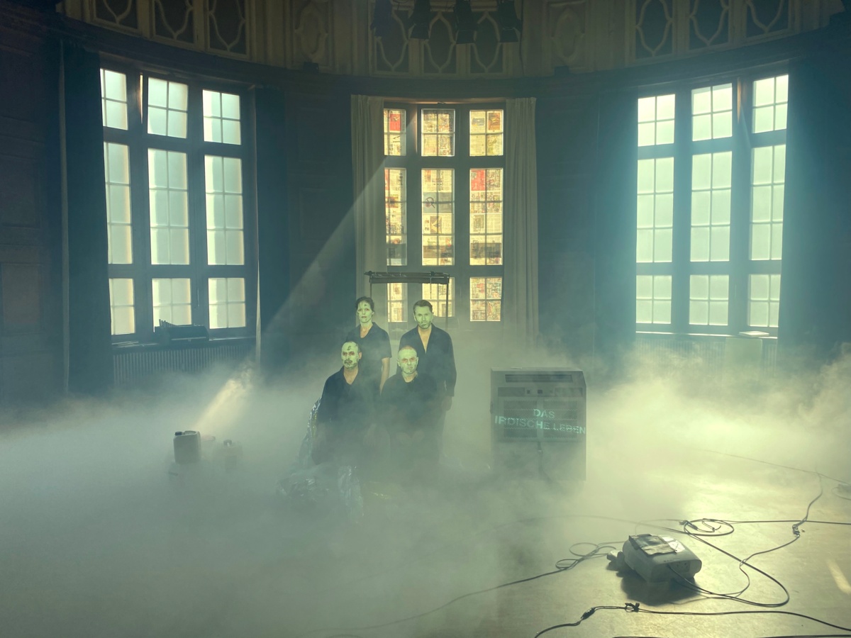 Vier Musiker:innen sitzen in dem vernebelten Konzertsaal.